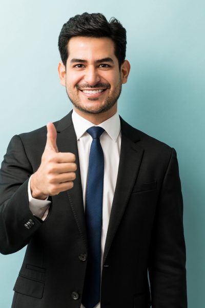 Portrait Of Businessman Showing Hand Sign In Studio